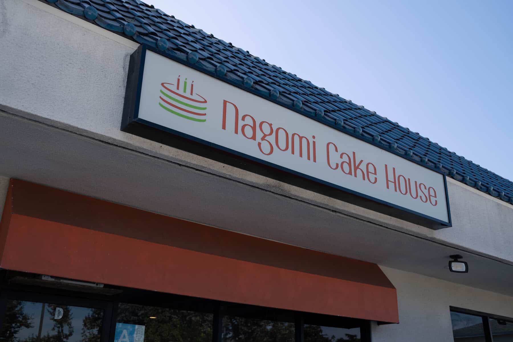 Nagomi Cake House 店面外觀,標誌性橘紅字體與蛋糕 Logo
