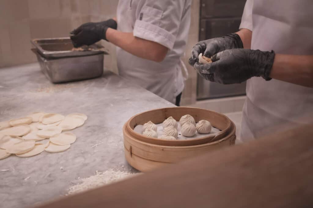 鼎泰豐 Downtown Disney 餐廳內，兩位師傅正在手工包製小籠包。